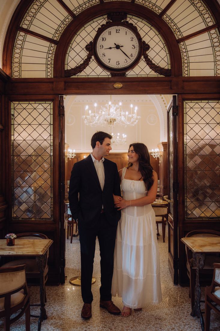 Nicole and Bennett arm in arm under the clock